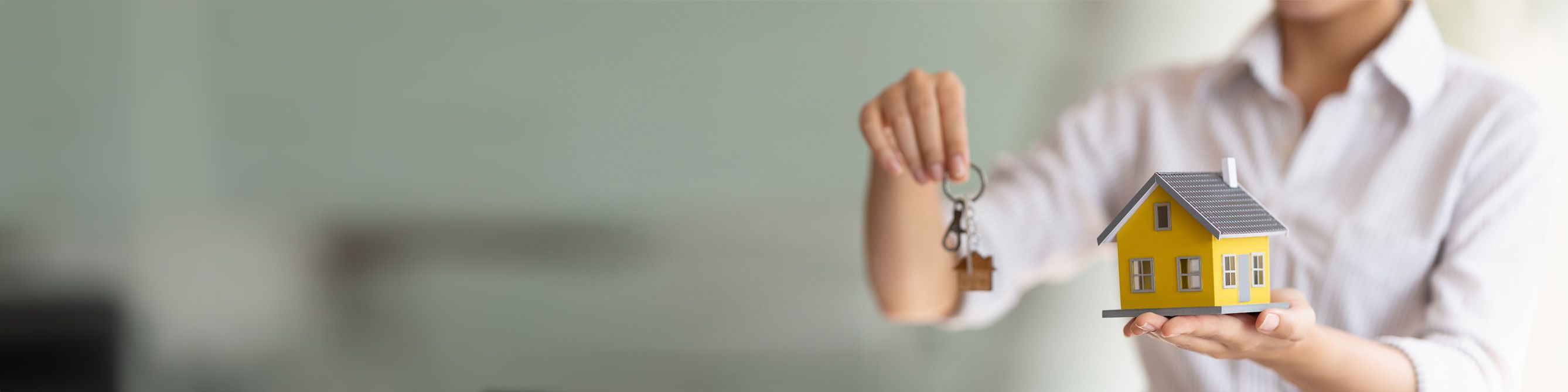 Einbruchdiebstahl Mann mit Schlüssel und kleinem gelben Haus in der Hand