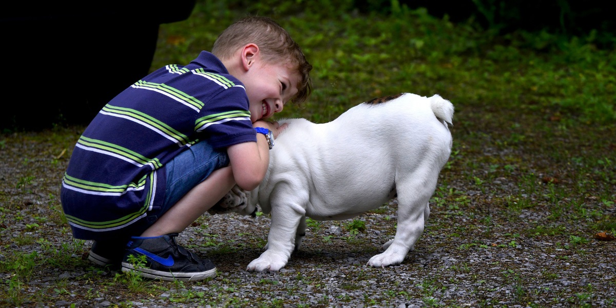 Kleiner Junge knuddelt mit seinem Hund