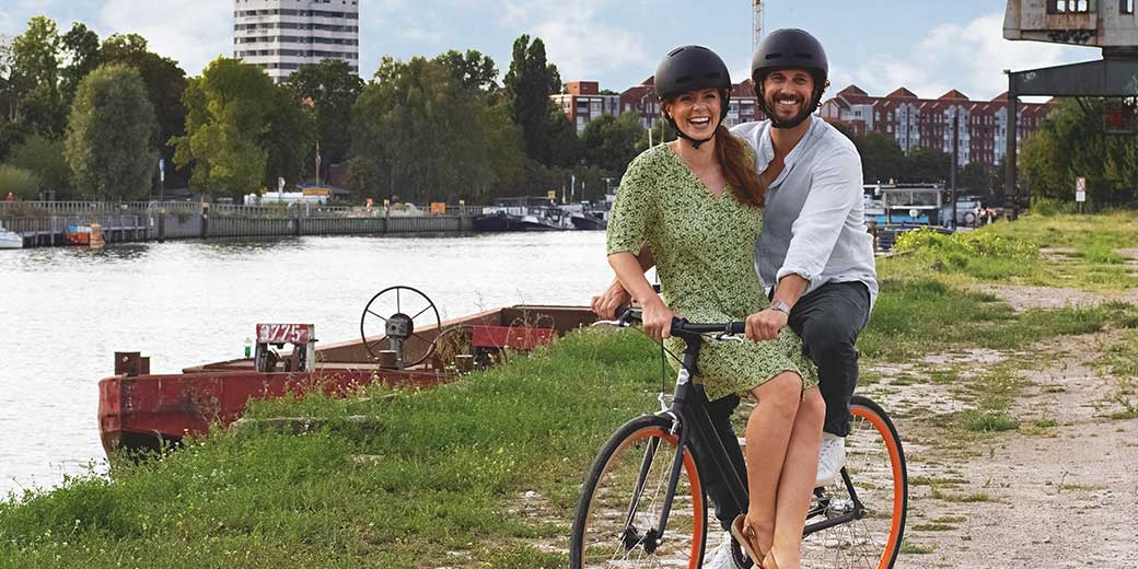 Krankenhauszusatzversicherung: Mittelaltes Paar auf einem Fahrrad